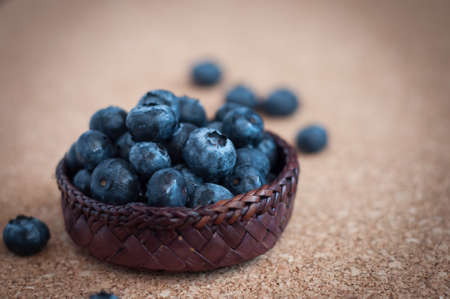 Freshly picked blueberries in woven natural screw pine leaf bowl. Juicy and fresh blueberries with on rustic table. Bilberry on wooden Background. Blueberry antioxidant. Concept for healthy eating.の写真素材