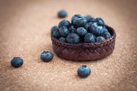 Freshly picked blueberries in woven natural screw pine leaf bowl. Juicy and fresh blueberries with on rustic table. Bilberry on wooden Background. Blueberry antioxidant. Concept for healthy eating.の写真素材