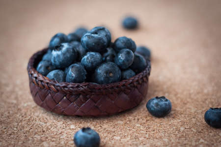 Freshly picked blueberries in woven natural screw pine leaf bowl. Juicy and fresh blueberries with on rustic table. Bilberry on wooden Background. Blueberry antioxidant. Concept for healthy eating.の写真素材