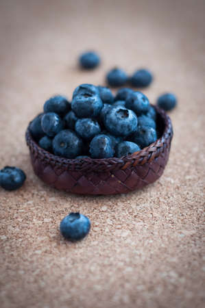 Freshly picked blueberries in woven natural screw pine leaf bowl. Juicy and fresh blueberries with on rustic table. Bilberry on wooden Background. Blueberry antioxidant. Concept for healthy eating.の写真素材