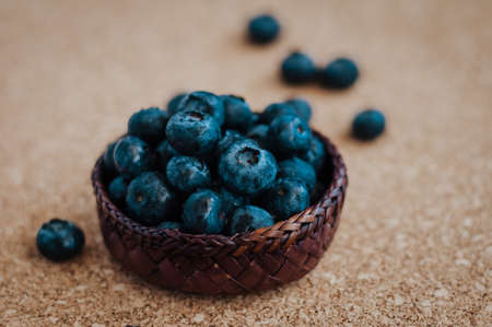 Freshly picked blueberries in woven natural screw pine leaf bowl. Juicy and fresh blueberries with on rustic table. Bilberry on wooden Background. Blueberry antioxidant. Concept for healthy eating.の写真素材