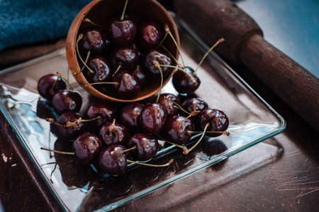 Fresh cherry on clear plate on wooden background. fresh ripe cherries. sweet cherries.の写真素材