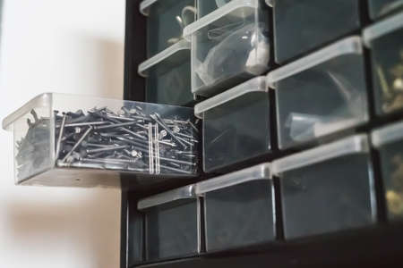 Screws in the mini plastic drawer. close up on the pile of screws.