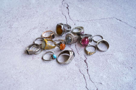 Vintage collection of man's old rings on the concrete background.