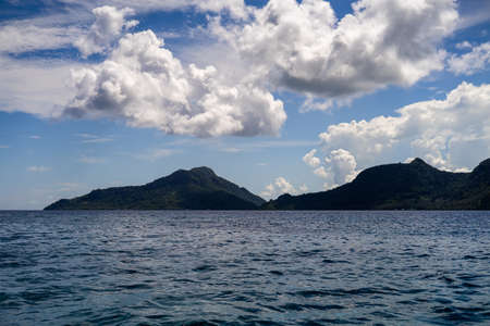 Celebes sea surface summer wave background. Exotic water landscape with clouds and island on horizon. Natural tropical water paradise. Semporna nature relax. Travel tropical island resort. Ocean nature tranquility.の写真素材