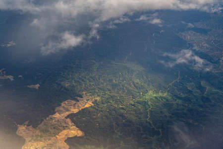 Scenery from window on Airplane with blue sky and clouds. Top view scenery showing perfect natural river, green forest on mountain at Sabah. Travel and Transportation concept.の写真素材