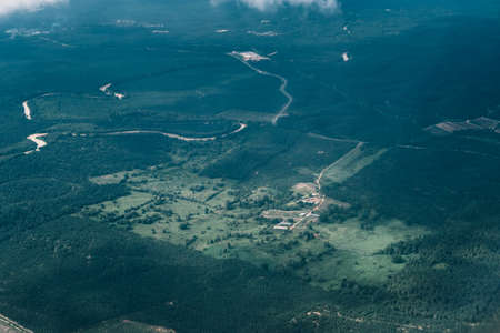 Scenery from window on Airplane with blue sky and clouds. Top view scenery showing perfect natural river, green forest on mountain at Sabah. Travel and Transportation concept.の写真素材