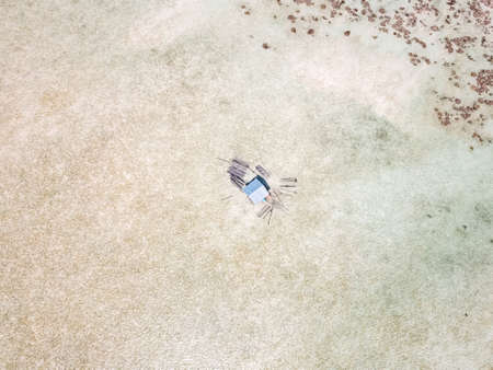 Over water small hut of cage fisherman. Blue azure turquoise lagoon with corals. Emerald Pulau Bum Bum island in Sampoerna, Sabah, Malaysia.の写真素材