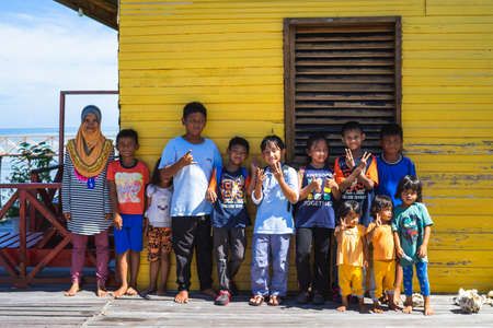 Semporna, Malaysia - November 27, 2019 :  Children taking photo together before saying goodbye after spending school holiday together.の写真素材