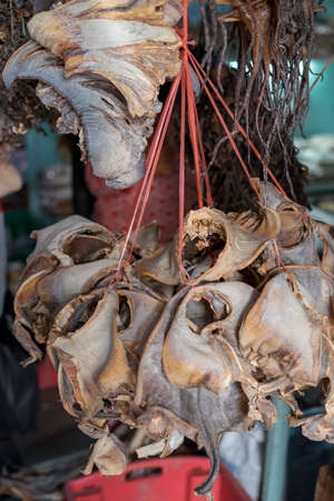 Dried fish tied into several bundles for sale, hanging from above, in a local fish market in Semporna, Sabah.の写真素材