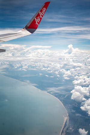 Tawau, Malaysia - Nov 24, 2019: Air Asia aircraft wing flying over clouds on a sunny day.のeditorial素材