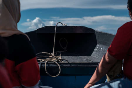 Rope in a boat with unidentified people sitting.の写真素材