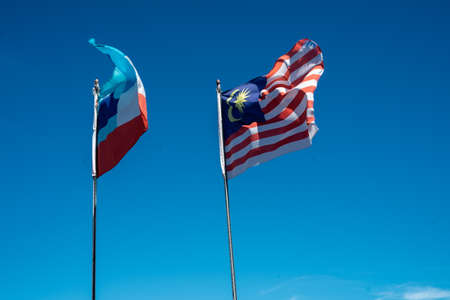 Malaysia and Sabah flags waving with blue sky in the background.の写真素材