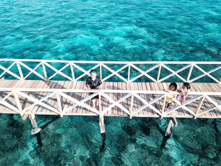 aerial top view of wooden pier bridge, walkway to the sea in cleared and clean seawaterの写真素材