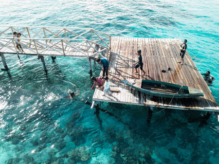 Aerial view of children playing at pier, in Semporna, Borneo Sabah, Malaysia.の写真素材