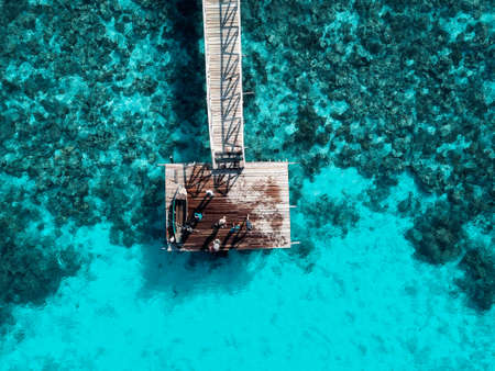 Top down aerial view over the end of wooden Jetty with unidentified kids on it.の写真素材