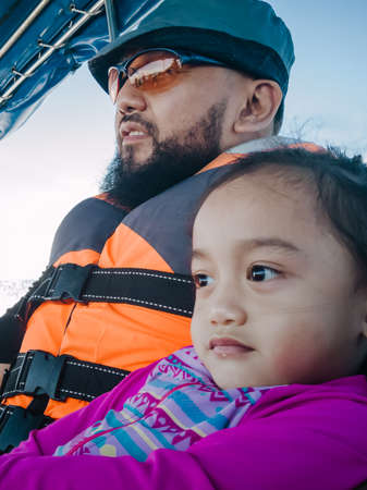 Father and toddler daughter on a boat during holiday vacation in a tropical island.の写真素材