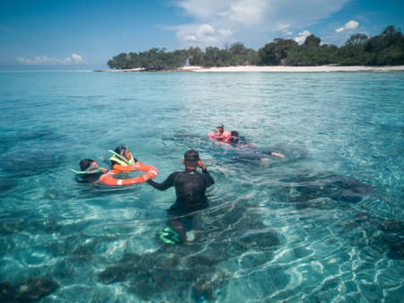 People in snorkeling mask dive underwater with tropical fishes in coral reef sea pool. Travel lifestyle, water sports, outdoor adventure, swimming family summer beach holiday with kidsの写真素材