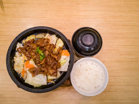 spicy grilled beef rice set close up shot on a wooden table.