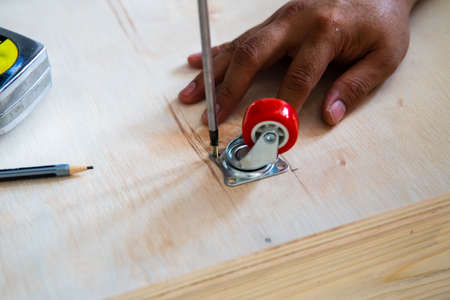 Fixing castor wheel to the wooden plywood, furniture making.