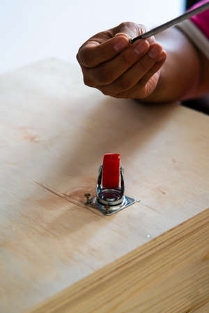Fixing castor wheel to the wooden plywood, furniture making.