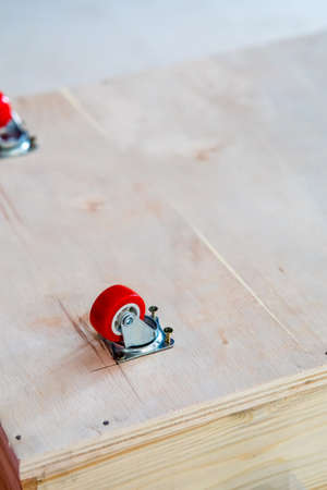 Fixing castor wheel to the wooden plywood, furniture making.