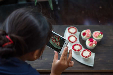 Beautiful cup cakes flowers from butter cream, in red and pink colour. Suitable for Birthday, Anniversary, Valentine Day and festive. selective focusの写真素材
