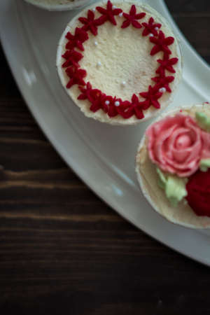 Beautiful cup cakes flowers from butter cream, in red and pink colour. Suitable for Birthday, Anniversary, Valentine Day and festive. selective focusの写真素材