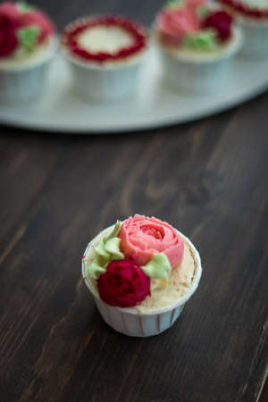 Beautiful cup cakes flowers from butter cream, in red and pink colour. Suitable for Birthday, Anniversary, Valentine Day and festive. selective focusの写真素材