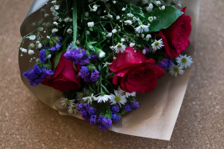 bouquet of roses arrangements of flowers in a paper wrapper on wooden backgroundの写真素材