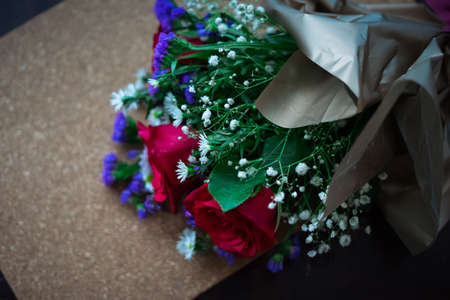 bouquet of roses arrangements of flowers in a paper wrapper on wooden backgroundの写真素材
