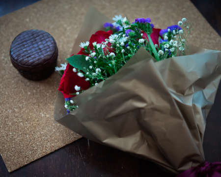 bouquet of roses arrangements of flowers in a paper wrapper on wooden backgroundの写真素材