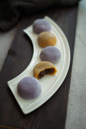 Multi-colored Japanese Mochi in rice dough and on a wooden background. Traditional Japanese dessert.
