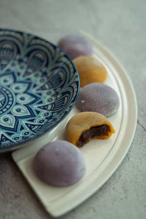 Multi-colored Japanese Mochi in rice dough and on a beautiful plate and concrete background....