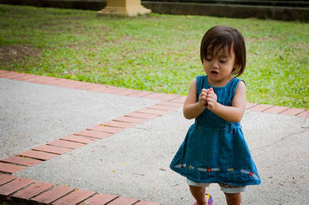 Asian 1 year old toddler is busy playing in a tropical park in the morning.の写真素材