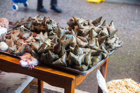 Close up view of Chinese Glutinous Rice Dumplings (zongzi) on the stall for sale. Sticky rice, triangle or cone shaped. Traditional food for celebrating Duanwu festival, aka Dragon boat festivalのeditorial素材