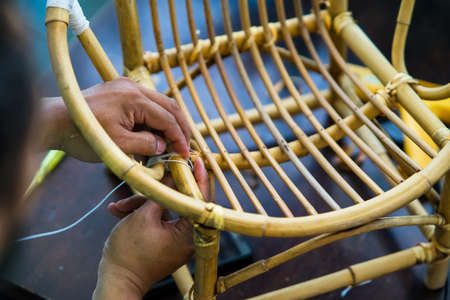 Restoration of rattan chair with white thread. Recycling, upcycling and from trash to reasure concept. Reuse for the environment.の写真素材