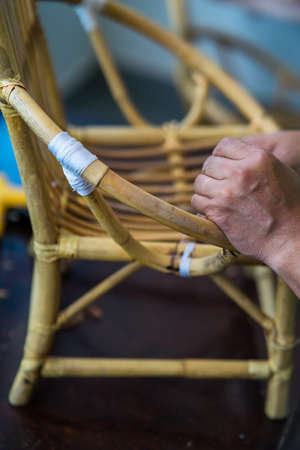 Restoration of rattan chair with white thread. Recycling, upcycling and from trash to reasure concept. Reuse for the environment.の写真素材