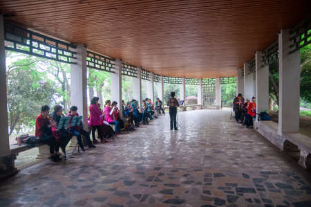 wuhAN,CHINA - April 4, 2019 - Senior woman practicing a Hulusi or Curcubit flute at the Ting Tao Scenic Hall.のeditorial素材