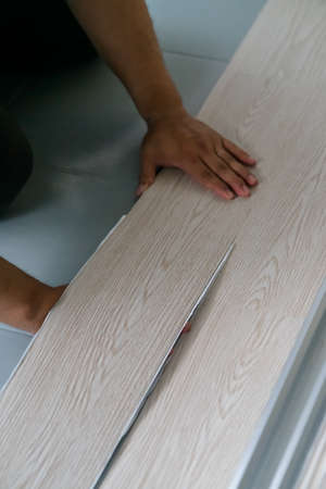 A person installing new vinyl tile floor, a DIY home project.の写真素材