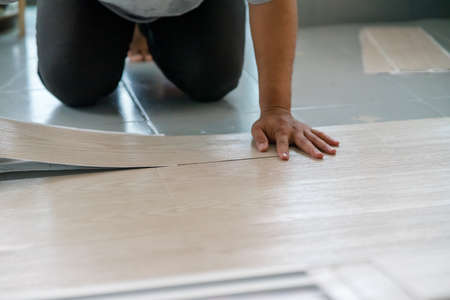 A person installing new vinyl tile floor, a DIY home project.の写真素材