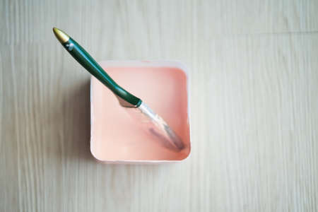Copy space with a paint brush in a box full of paint on wooden clean floor. Top viewの写真素材