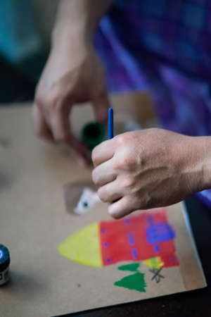 art, creativity and people concept - hand of artist with brush painting pictureの写真素材