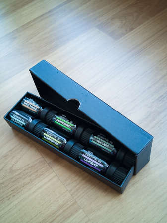 Selection of essential oils, in a black matte box on a wooden background. Gift set.
