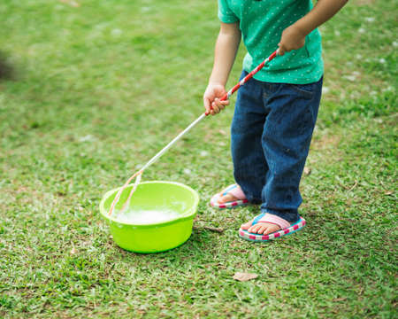 Lovely active little asian girl playing with soap bubble outdoor in the parkの写真素材
