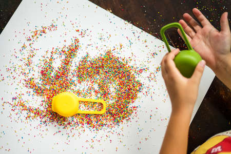 Playing with the colourful sugar sprinkles. Fun activites for children. Fine motor skills.の写真素材