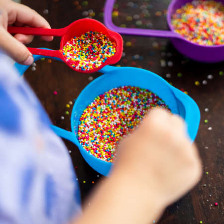 Playing with the colourful sugar sprinkles. Fun activites for children. Fine motor skills.の写真素材