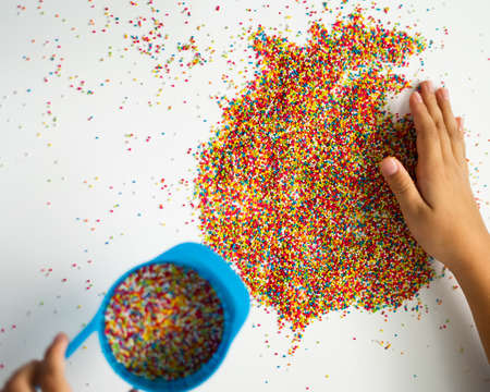 Playing with the colourful sugar sprinkles. Fun activites for children. Fine motor skills.の写真素材