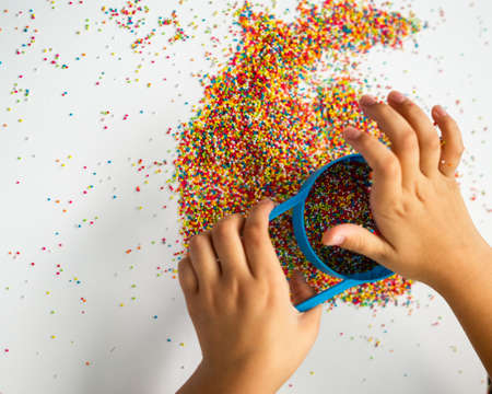 Playing with the colourful sugar sprinkles. Fun activites for children. Fine motor skills.の写真素材