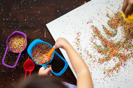 Playing with the colourful sugar sprinkles. Fun activites for children. Fine motor skills.の写真素材